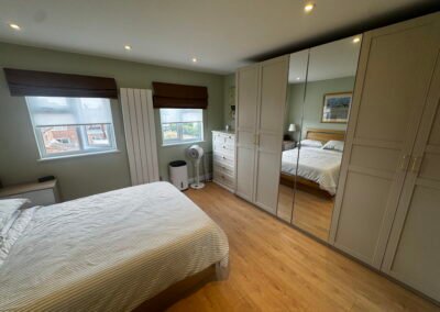 Master bedroom in a Windsor loft conversion with large rear windows