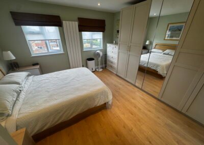 Master bedroom in a Windsor loft conversion with large rear windows