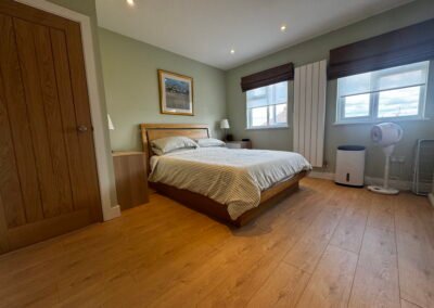 Master bedroom in a Windsor loft conversion with large rear windows