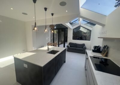 Open-plan kitchen extension in Acton with island and grey units